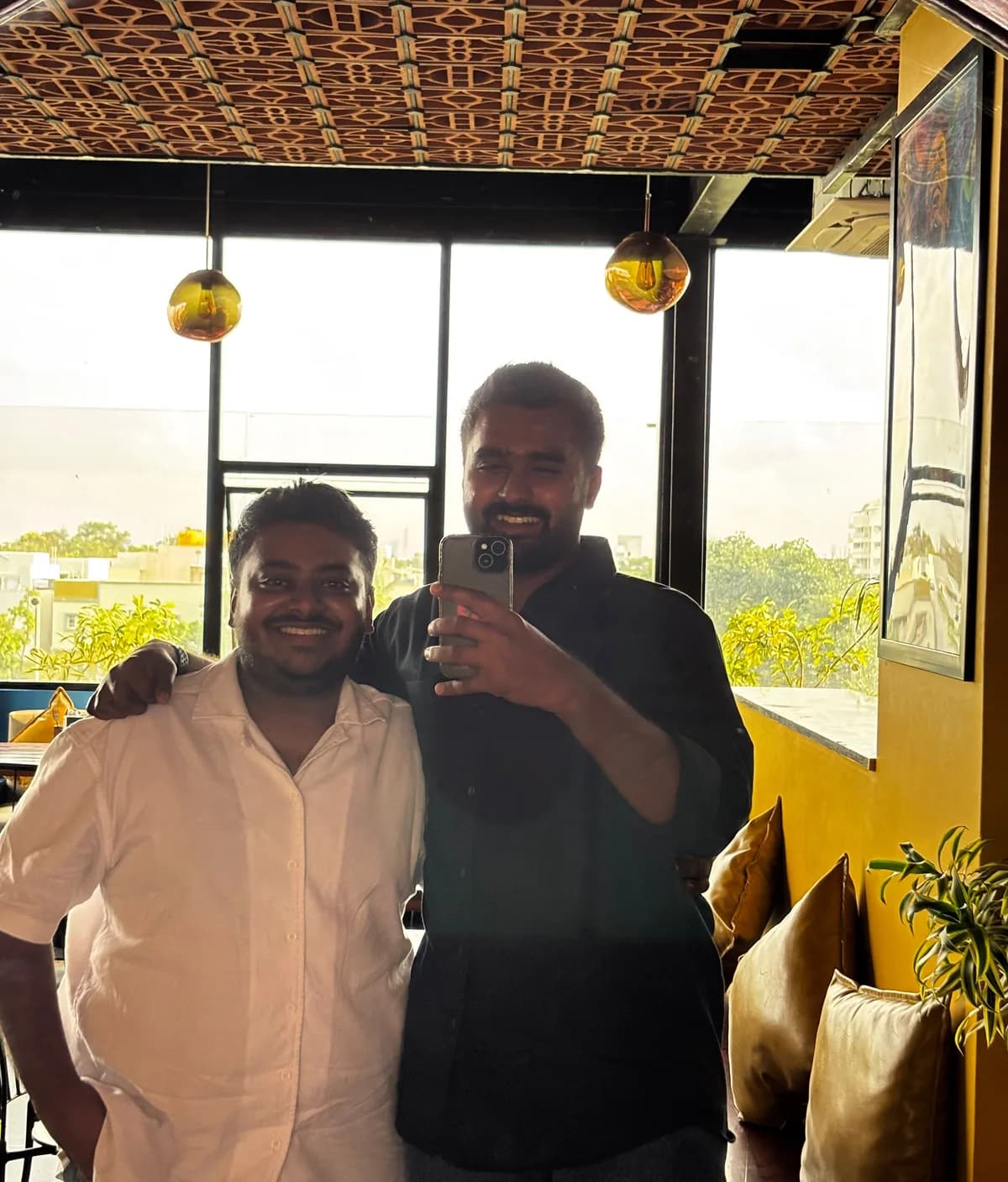 Samarth and Dhanush photographed together in Bangalore in 2026, twenty years after the class photograph.